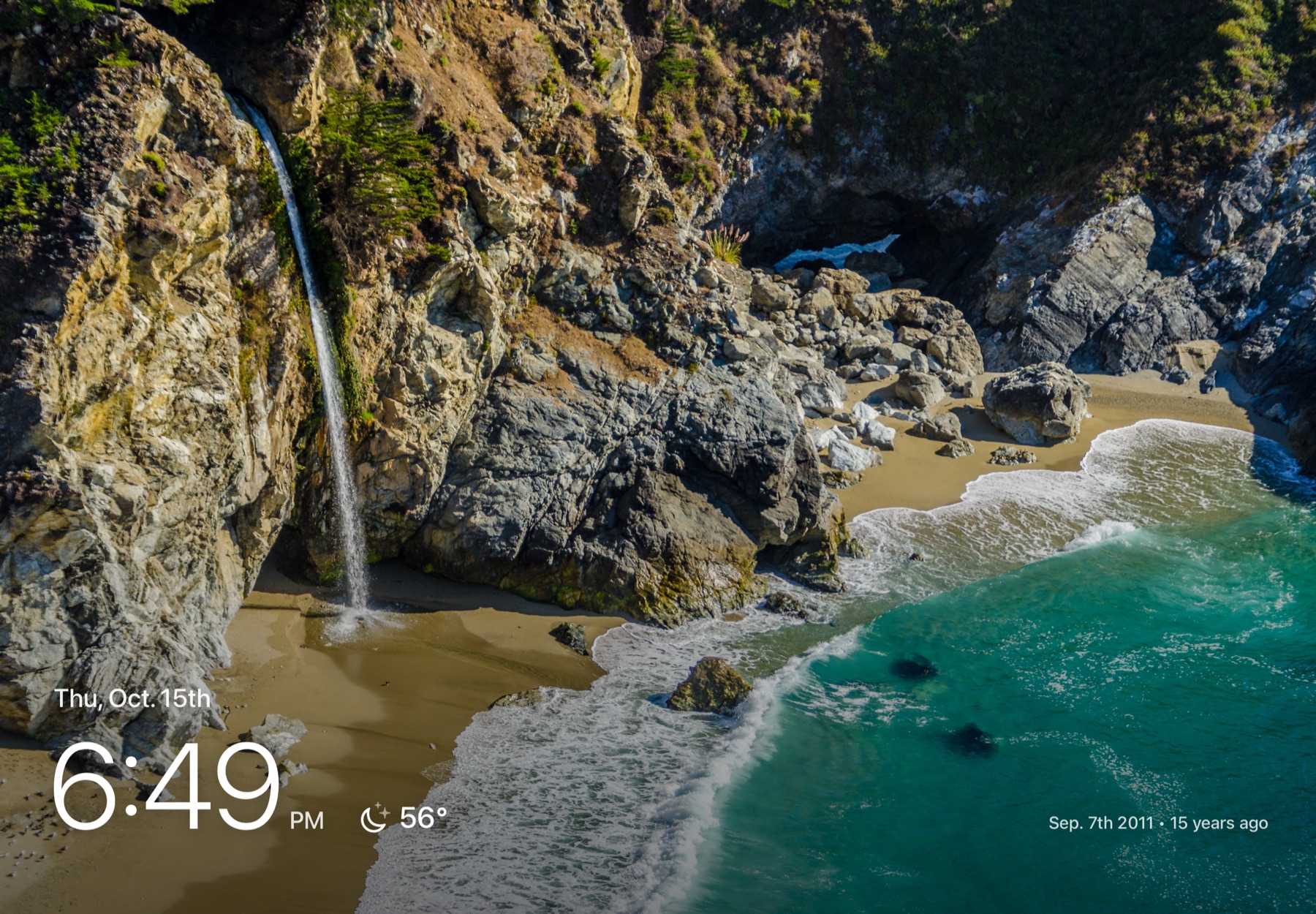 Everglow in Day Mode: a coastal waterfall photo with the time, date, and weather in the corner.